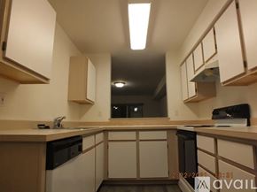 Seattle apartment for rent - A kitchen with black appliances and wooden cabinets.