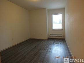 Seattle apartment for rent - A room with wooden flooring and a window showing a snowy landscape outside.