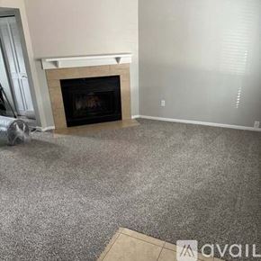 Colorado Springs townhouse for rent - A living room with a fireplace and grey carpet.