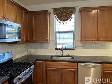 Castaic house for rent - A kitchen with wooden cabinets and a stainless steel dishwasher.