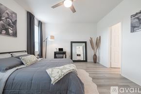 Bastrop house for rent - A bedroom with a large bed and a ceiling fan.