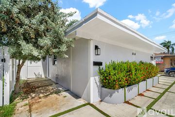Fort Lauderdale apartment for rent - A black refrigerator is in a kitchen with white cabinets.