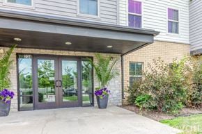 Whitewater apartment for rent - The front of a building with a glass door and windows.