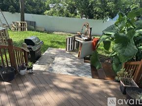 Tampa house for rent - A backyard with a wooden deck and a trash can.