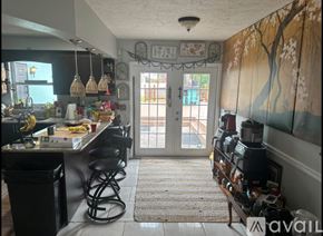 Tampa house for rent - A kitchen with a bar stool and a counter with food on it.