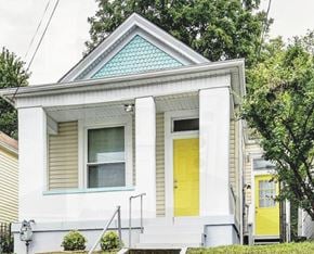 Louisville house for rent - A small white house with a yellow door and a blue window.
