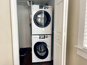 Louisville house for rent - A white front load washing machine in a small laundry room.