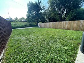 Louisville apartment for rent - A backyard with a wooden fence and green grass.