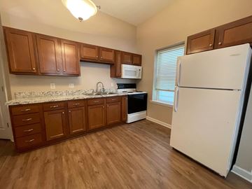 Louisville apartment for rent - A kitchen with wooden cabinets and a white refrigerator.