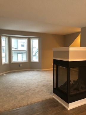 Fort Mcmurray house for rent - A living room with a fireplace and carpeted floor.