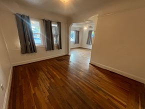 Stockton house for rent - A room with wooden flooring and a window with curtains.