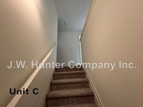 Wilson apartment for rent - A staircase in a building with the text "J.W. Hunter Company Inc. Unit C" displayed.