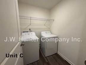 Wilson apartment for rent - A laundry room with two washing machines and a sign that says J.W. Hunter Company Inc.