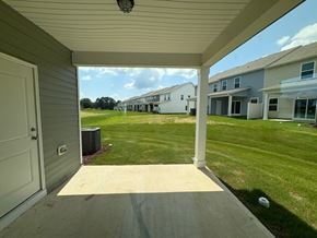 Wilson apartment for rent - A view from a doorway looking out to a grassy area with houses in the distance.