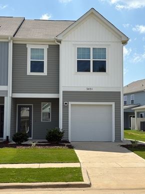 Wilson apartment for rent - A two-story house with a garage door and a window on the front.