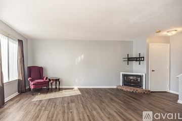 Wallingford apartment for rent - A living room with a red chair and a fireplace.