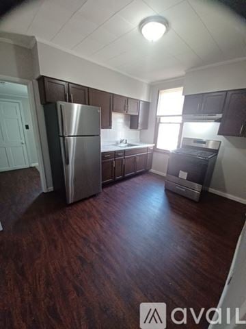 St. Louis house for rent - A kitchen with dark wood floors and stainless steel appliances.