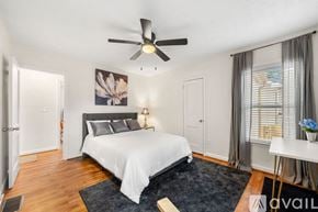 Hapeville house for rent - A bedroom with a large bed and a ceiling fan.