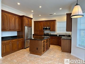 Celebration house for rent - A kitchen with wooden cabinets and a black countertop.