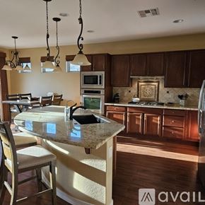 Peoria house for rent - A kitchen with a granite countertop and wooden cabinets.