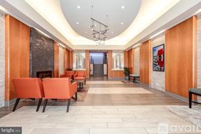 Washington condo for rent - A spacious hallway with orange chairs and a staircase in the background.
