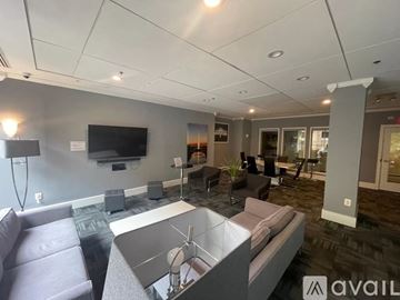 Washington condo for rent - A modern living room with a grey sofa and a television on the wall.