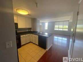 Washington condo for rent - A kitchen with white cabinets and a black dishwasher.