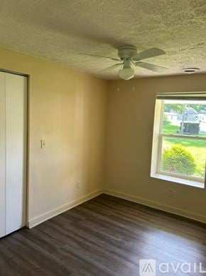 Bemus Point apartment for rent - A room with a ceiling fan and a window showing a green lawn outside.