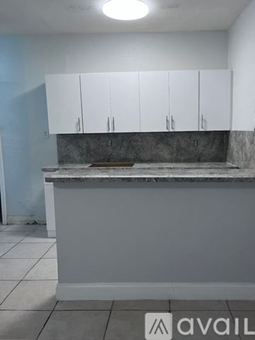Coral Gables apartment for rent - A kitchen with white cabinets and a marble countertop.