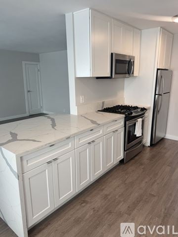Santa Monica apartment for rent - A kitchen with white cabinets and a marble countertop.