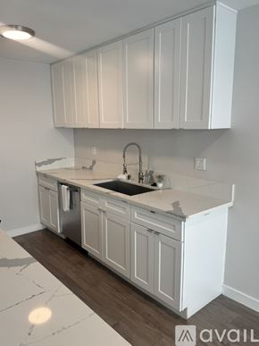 Santa Monica apartment for rent - A kitchen with white cabinets and a marble countertop.