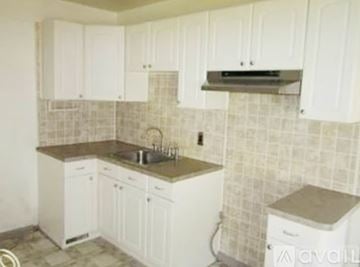Warren house for rent - A kitchen with white cabinets and a tiled backsplash.
