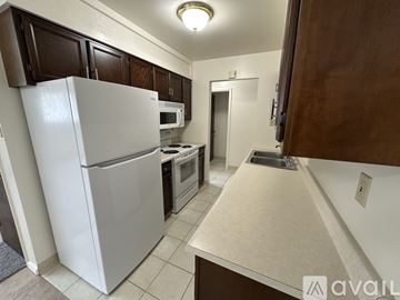 Billings apartment for rent - A kitchen with a white refrigerator and brown cabinets.