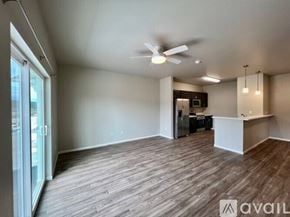 Summerset apartment for rent - A spacious room with a ceiling fan and a kitchenette in the background.