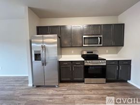 Summerset apartment for rent - A kitchen with a stainless steel refrigerator, microwave, and oven.