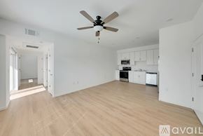Hanford Ca apartment for rent - A spacious room with a ceiling fan and wooden flooring.