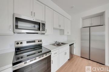 Hanford Ca apartment for rent - A kitchen with white cabinets and stainless steel appliances.