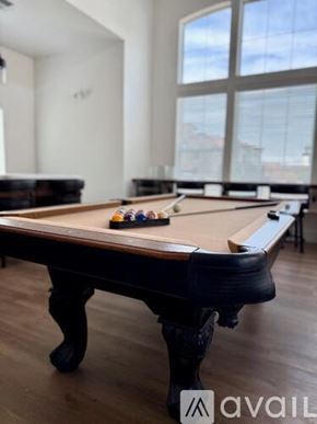 Hanford Ca apartment for rent - A pool table in a room with a large window.