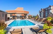 Alexandria apartment for rent - A large outdoor swimming pool surrounded by lounge chairs and umbrellas.