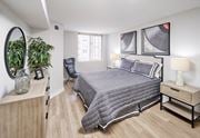 Alexandria apartment for rent - A bedroom with a bed, nightstand, and a plant.