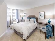 Washington apartment for rent - A bedroom with a large bed and a chair by the window.