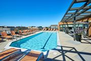 Washington apartment for rent - A large outdoor swimming pool with lounge chairs and a building in the background.