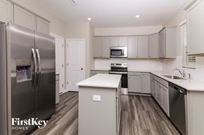 Four Oaks house for rent - A kitchen with a stainless steel refrigerator and wooden floors.