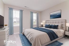 Four Oaks house for rent - A bedroom with a large bed, a television, and a painting on the wall.