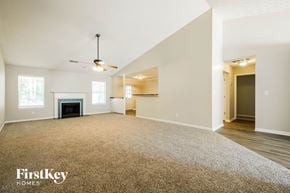 Winder house for rent - A spacious living room with a fireplace and a ceiling fan.