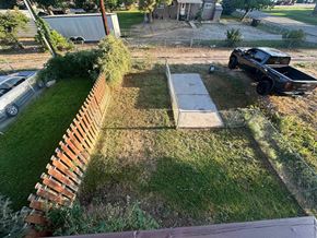 Silt house for rent - A black truck is parked on a grassy area next to a wooden fence.