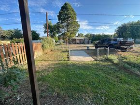 Silt house for rent - A black truck is parked behind a chain link fence in a yard.