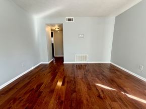Louisville apartment for rent - A room with wooden flooring and a doorway leading to another room.