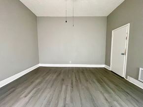 Louisville apartment for rent - A room with a wooden floor and a white door.
