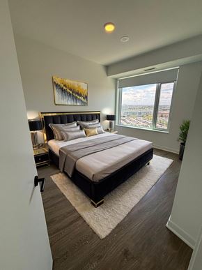 Mississauga apartment for rent - A bedroom with a large bed and a painting on the wall.